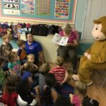 ELC reading volunteer Sara Pines and special guest Curious George read books from the book bag project to children at Green Gables Learning Center in Palatka.