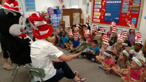 ELC volunteers Ginny Dozier and Erika Bauserman with special guest the Cat in the Hat reading the book “Ten Apples Up on Top” by Dr. Seuss to children at Brighton Day Academy in St. Augustine